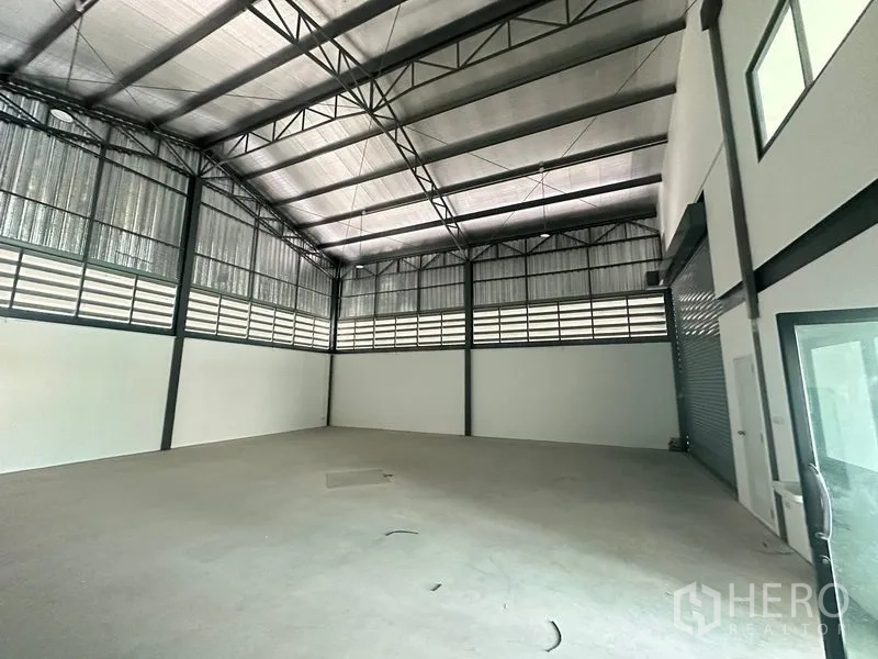工厂 出租或出售在Bang Bua Thong, Nonthaburi - 厂房内部挑高空间，钢桁架、隔热屋顶与光滑混凝土地面。