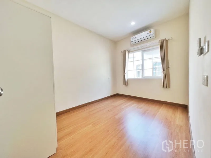 联排别墅 出租或出售在Phra Pradaeng, Samut Prakan - 带空调的卧室，大窗与木纹地板。