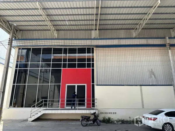 โรงงาน ให้เช่าในBang Phli, Samut Prakan - ทางเข้าออฟฟิศกระจกพร้อมแผงสีแดงและบันไดยกสูงใต้กันสาดโลหะขนาดใหญ่