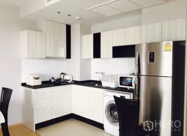 คอนโด ให้เช่าในWatthana, Bangkok - ครัวรูปตัวแอลสไตล์โมเดิร์น ตู้สีขาว ท็อปสีดำ เครื่องซักผ้า ไมโครเวฟ และตู้เย็นสแตนเลส