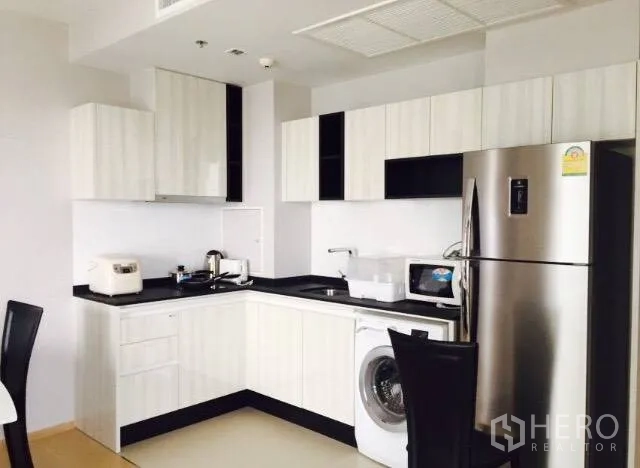 คอนโด ให้เช่าในWatthana, Bangkok - ครัวรูปตัวแอลสไตล์โมเดิร์น ตู้สีขาว ท็อปสีดำ เครื่องซักผ้า ไมโครเวฟ และตู้เย็นสแตนเลส