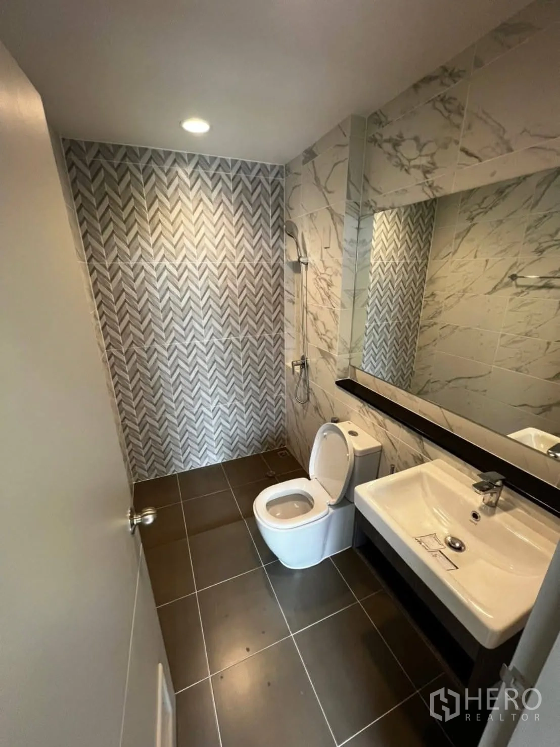 Townhouse for rent in Bang Khen, Bangkok - Primary bedroom with ensuite doorway leading to a patterned-tile bathroom.