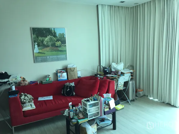 公寓 出租在Watthana, Bangkok - 客厅配红色沙发，转角落地窗帘、书桌与茶几，采光充足。