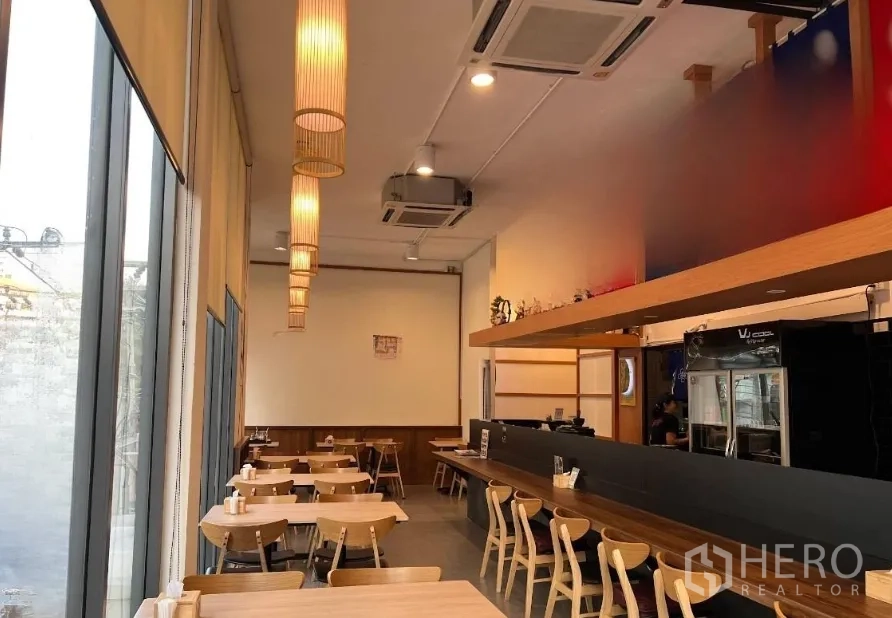 零售空间 出租在Watthana, Bangkok - 商铺全景，玻璃立面、吧台座位与天花空调设备。