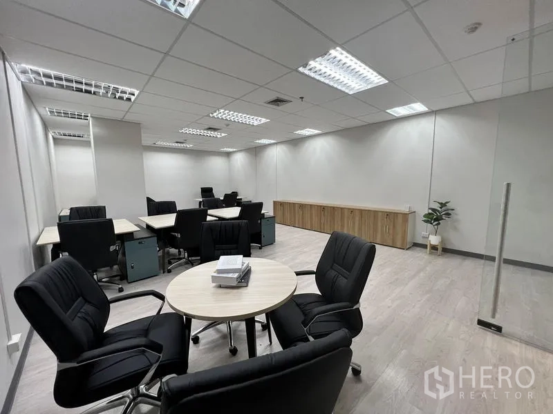 Office Space for rent in Sathon, Bangkok - Open-plan office area with round meeting table, multiple workstations, long storage credenza and bright ceiling lights.