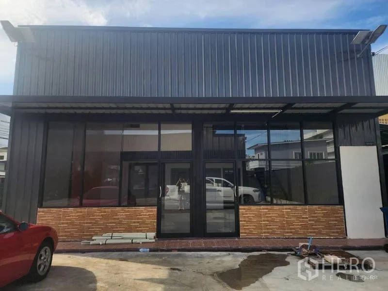 Warehouse for rent in Suan Luang, Bangkok - Straight-on view of the warehouse facade with a wide glass storefront.