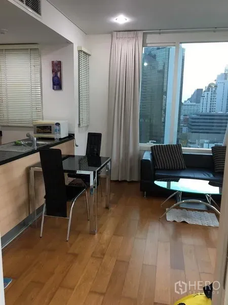 Condominium for rent in Watthana, Bangkok - Open-plan living and dining area with wood flooring and city views.