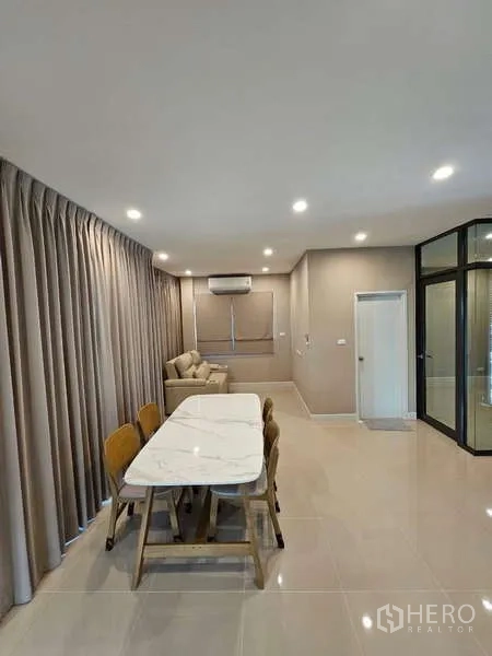 Detached House for rent in Bang Phli, Samut Prakan - Open-plan living and dining area with a marble-top table and long drapes.