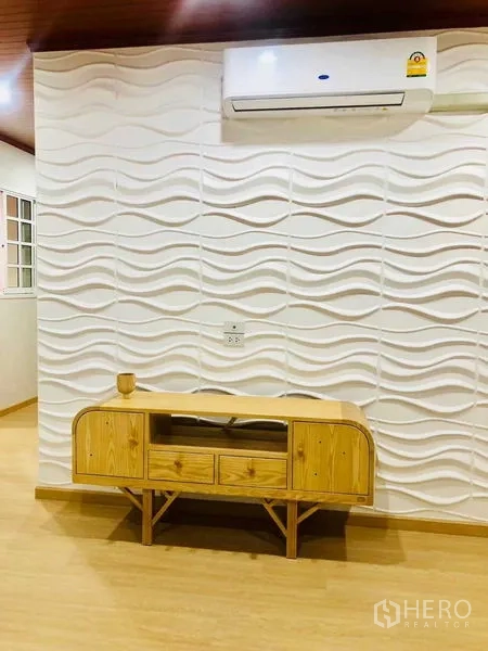 Home Office for rent or sale in Pak Kret, Nonthaburi - Feature wall with 3D wave panels, wooden console and air conditioner in a living space.