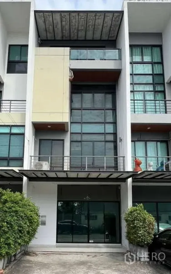Home Office for rent in Bueng Kum, Bangkok - Modern multi-storey home office facade with full-height glass windows, balconies and driveway shrubs.