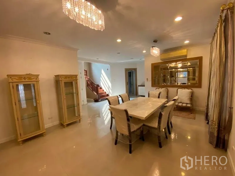 Detached House for rent in Bang Phli, Samut Prakan - Elegant dining room with chandelier lighting, marble-top table and glass display cabinets.