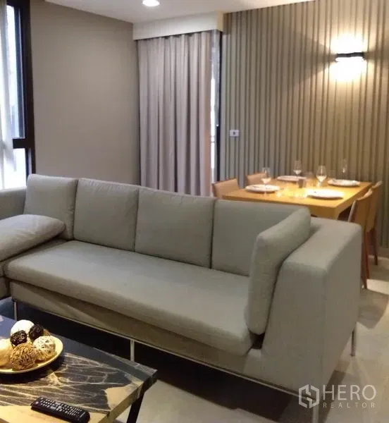 อพาร์ทเมนท์ ให้เช่าในKhlong Toei, Bangkok - ห้องนั่งเล่นสไตล์โมเดิร์น โซฟาสีเทา ชุดทานอาหาร และผ้าม่านสูงจรดเพดาน