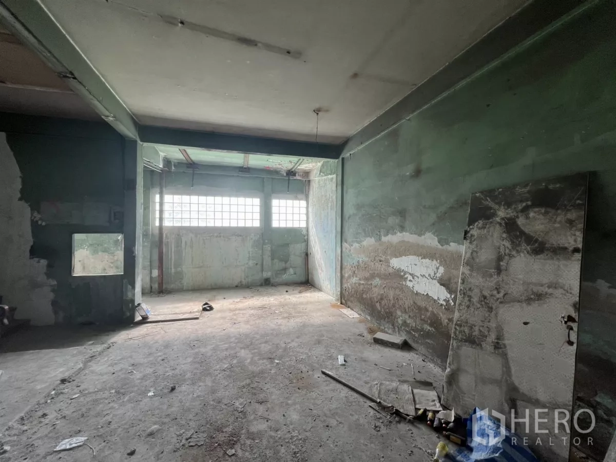 店屋 出售在Suan Luang, Bangkok - 水泥房间，绿色墙面与玻璃砖采光窗。