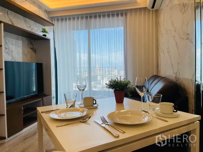 คอนโด ให้เช่าในBang Na, Bangkok - โต๊ะทานข้าวข้างชั้นวางทีวี มีผ้าม่านโปร่งเปิดสู่ระเบียง