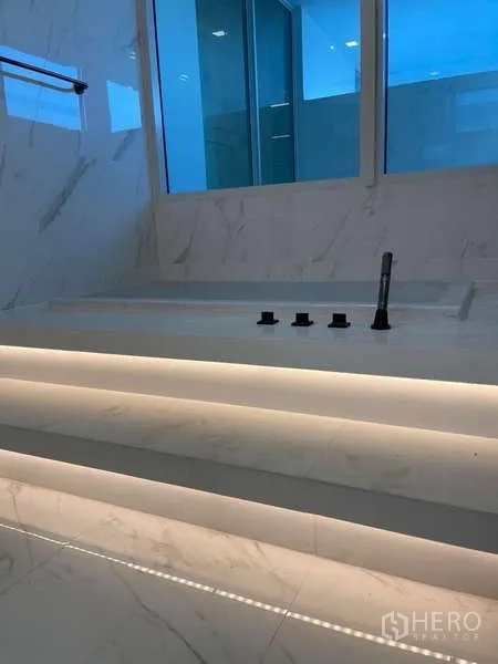 Detached House for rent in Bueng Kum, Bangkok - Step-lit marble platform bathtub area with window for natural light.