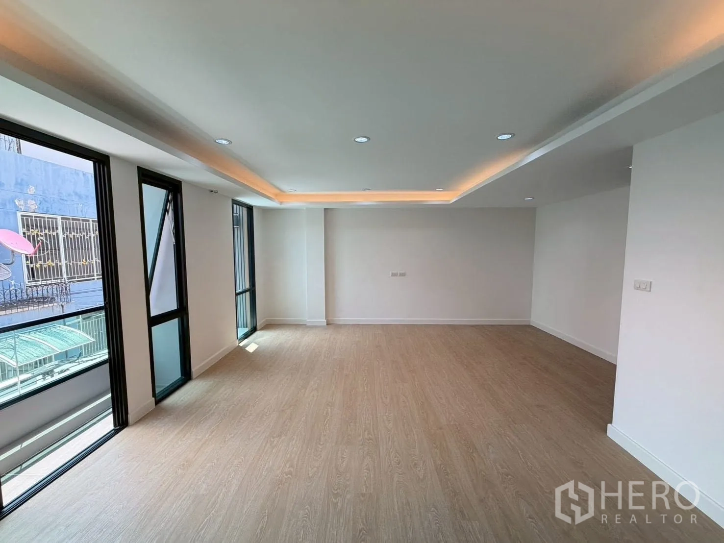 联排别墅 for sale in Phra Khanong, Bangkok - 宽敞多功能房大窗与灯槽照明。
