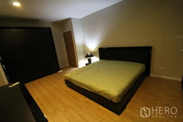 公寓 出租在Pathum Wan, Bangkok - 第二卧室，深色床架、床头灯与木地板。