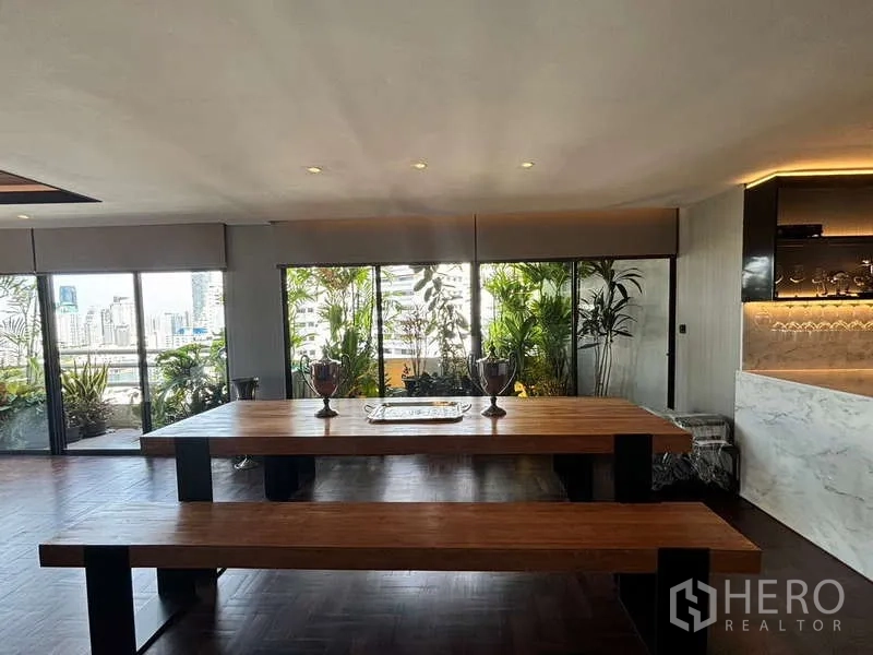 คอนโด ให้เช่าในWatthana, Bangkok - มุมรับประทานอาหารโต๊ะไม้ยาว ข้างหน้าต่างบานใหญ่และระเบียงสีเขียว