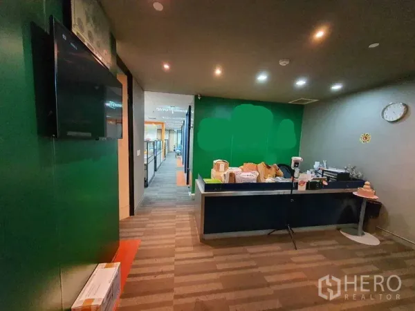 Office Space for rent in Watthana, Bangkok - Reception area with green feature wall, service counter and recessed downlights.