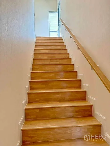 บ้าน ขายในLat Krabang, Bangkok - บันไดไม้พร้อมราวจับขึ้นสู่ชั้นบนที่สว่าง