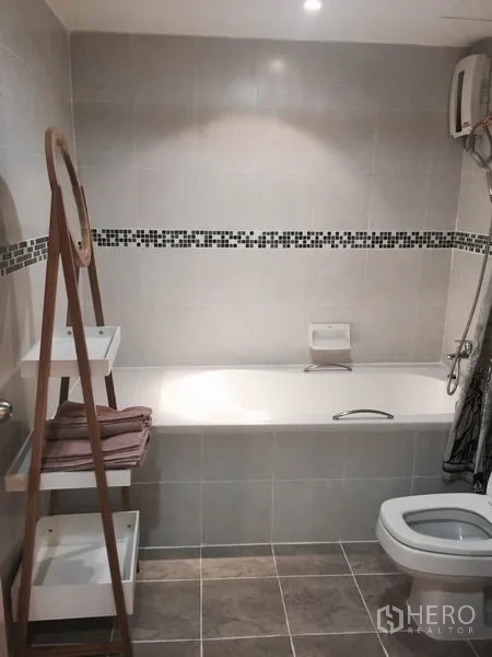 Condominium for rent or sale in Watthana, Bangkok - Contemporary bathroom featuring a built‑in bathtub, mosaic tile border, shower and ladder shelf.