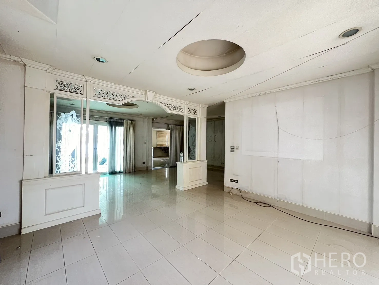 Detached House for sale in Saphan Sung, Bangkok - Living area with ornate divider, tiled flooring, and patio doors.