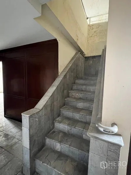 Shophouse for rent in Watthana, Bangkok - Internal stairway with stone tiles and handrail leading to upper levels.