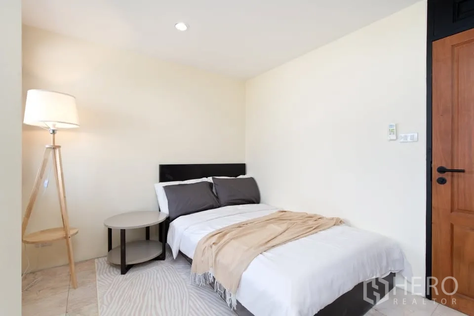 公寓 for rent in Watthana, Bangkok - 次卧温馨，双人床、落地灯与边几。