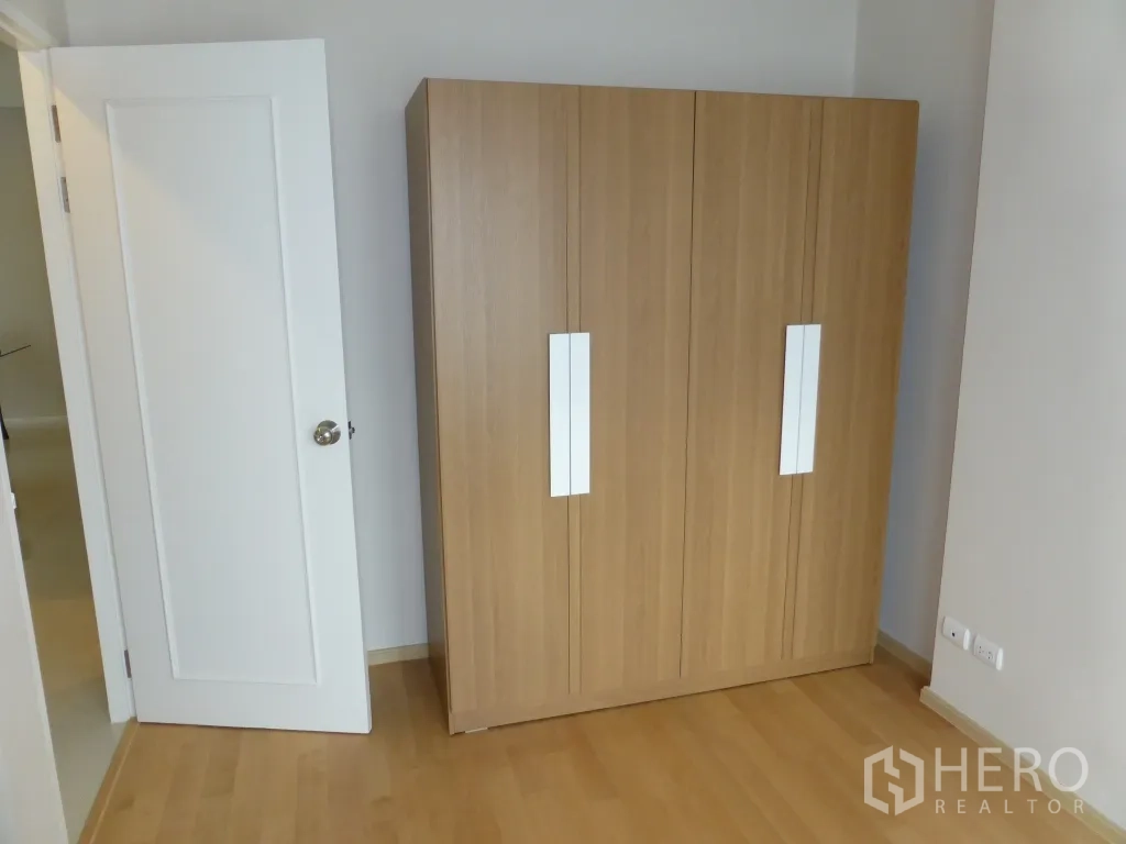 คอนโด ให้เช่าหรือขายในRatchathewi, Bangkok - ห้องเอนกประสงค์พร้อมตู้เสื้อผ้าไม้แบบตั้งพื้นและประตูสีขาว พื้นไม้