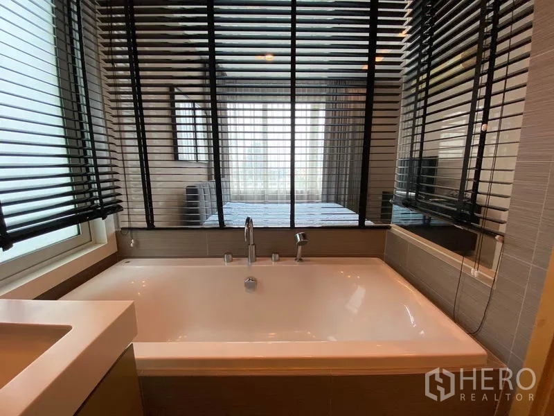 คอนโด ให้เช่าหรือขายในKhlong Toei, Bangkok - ห้องน้ำมาสเตอร์มีอ่างอาบน้ำใบใหญ่ข้างหน้าต่างและมู่ลี่กั้นสู่ห้องนอน
