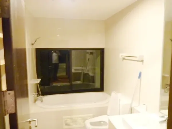 Condominium for rent in Watthana, Bangkok - Bright bathroom with bathtub, toilet and a large window.