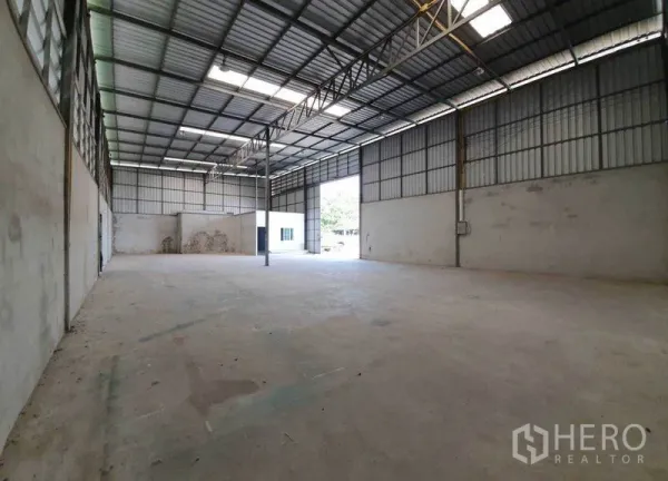 คลังสินค้า ให้เช่าในPathum Thani - พื้นที่เก็บของโปร่งโล่ง มีสกายไลต์ เสากลาง และประตูโรลเลอร์สำหรับรถบรรทุก