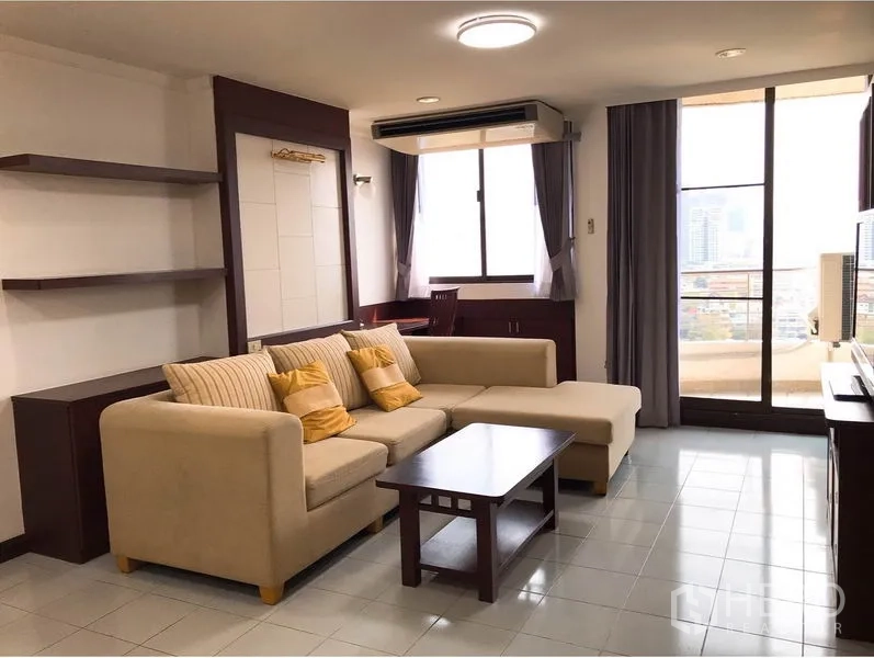 คอนโด ให้เช่าหรือขายในWatthana, Bangkok - มุมห้องนั่งเล่น โซฟาตัวแอล โต๊ะกลาง และประตูกระจกสูงออกสู่ระเบียงวิวเมือง