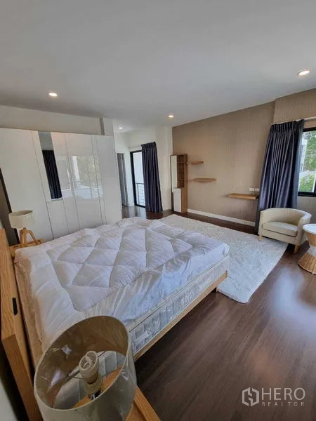 独立式住宅 出租或出售在Prawet, Bangkok - 采光卧室，衣柜、单椅与木地板。