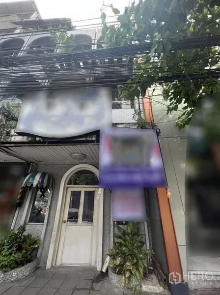 店屋 出租在Watthana, Bangkok - 曼谷Watthana区Ekkamai街边商铺外立面，拱形门与绿植。