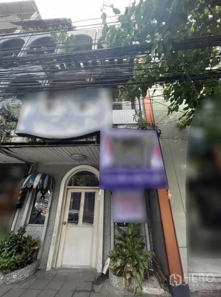 店屋 出租在Watthana, Bangkok - 曼谷Watthana区Ekkamai街边商铺外立面，拱形门与绿植。