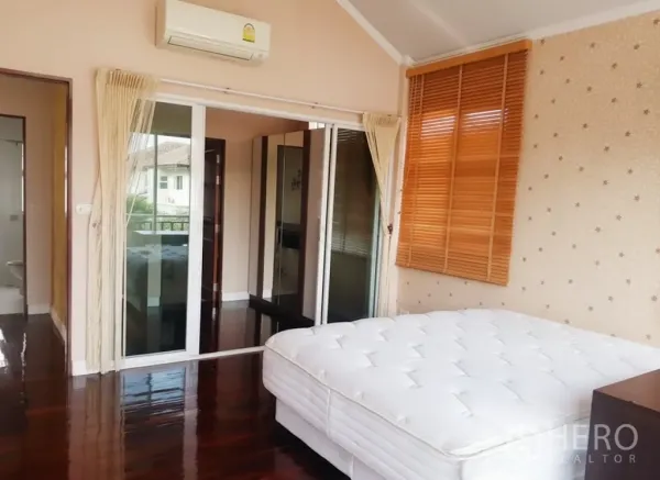 บ้าน ให้เช่าในLat Krabang, Bangkok - ห้องนอนชั้นบน มีประตูกระจกบานเลื่อนไปยังระเบียงและเครื่องปรับอากาศติดผนัง