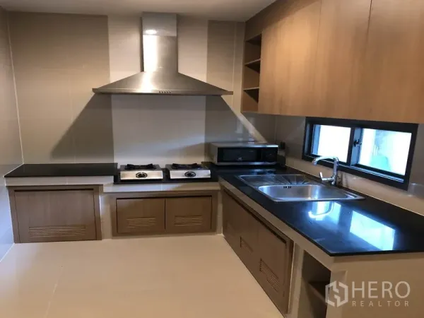 บ้าน ให้เช่าในBang Kapi, Bangkok - ครัวบิลท์อิน เคาน์เตอร์ดำ เตาแก๊ส เครื่องดูดควัน และอ่างสแตนเลส