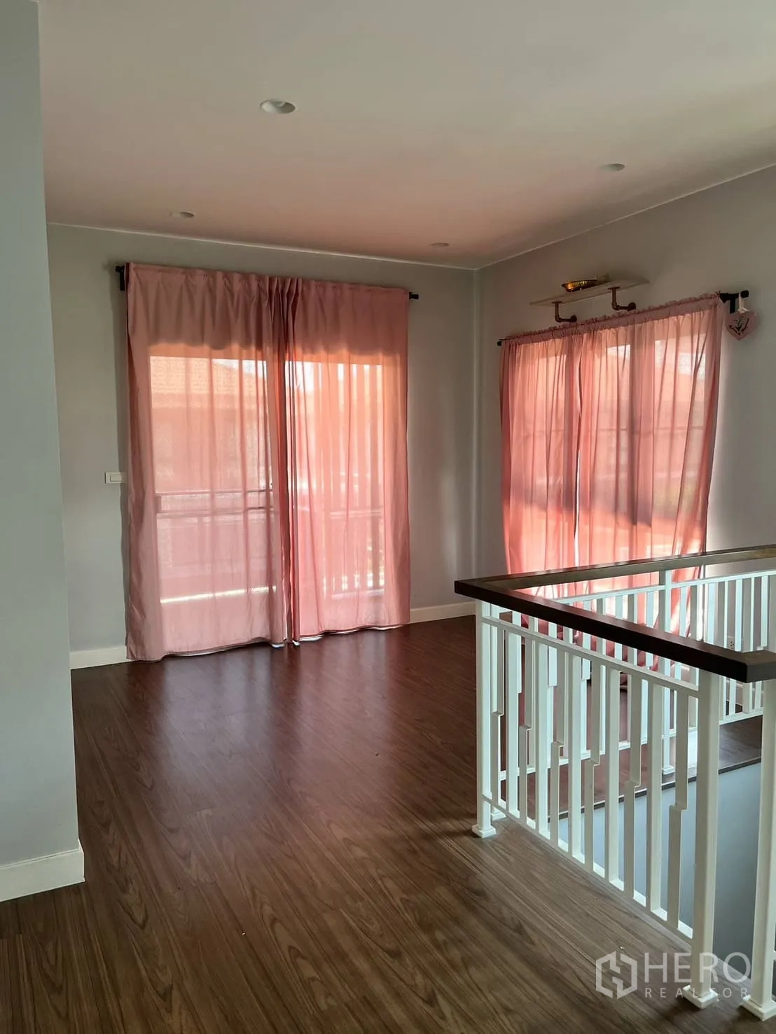 บ้าน ให้เช่าหรือขายในLam Luk Ka, Pathum Thani - อีกมุมของโถงชั้นบน ราวบันไดสีขาวและพื้นไม้