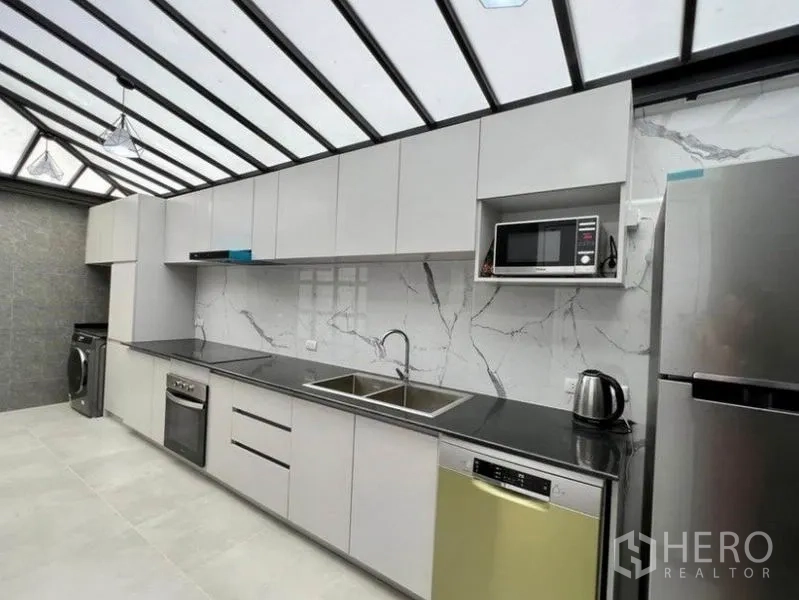 ทาวน์เฮาส์ ให้เช่าในWang Thonglang, Bangkok - ครัวสมัยใหม่หลังคาโปร่งแสง เคาน์เตอร์ยาว อ่างล้างคู่ เตาอบ เครื่องล้างจาน ตู้เย็น ไมโครเวฟ