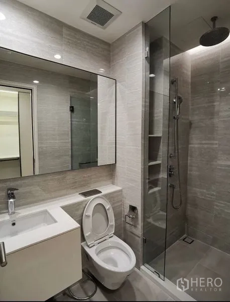 公寓 出租在Bang Rak, Bangkok - 现代卫浴配大镜面洗手台与玻璃隔断顶喷花洒。