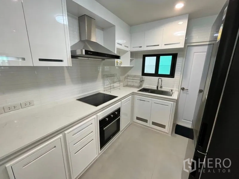 独立式住宅 出租在Phaya Thai, Bangkok - 现代白色欧式厨房，带烤箱、灶台与抽油烟机。