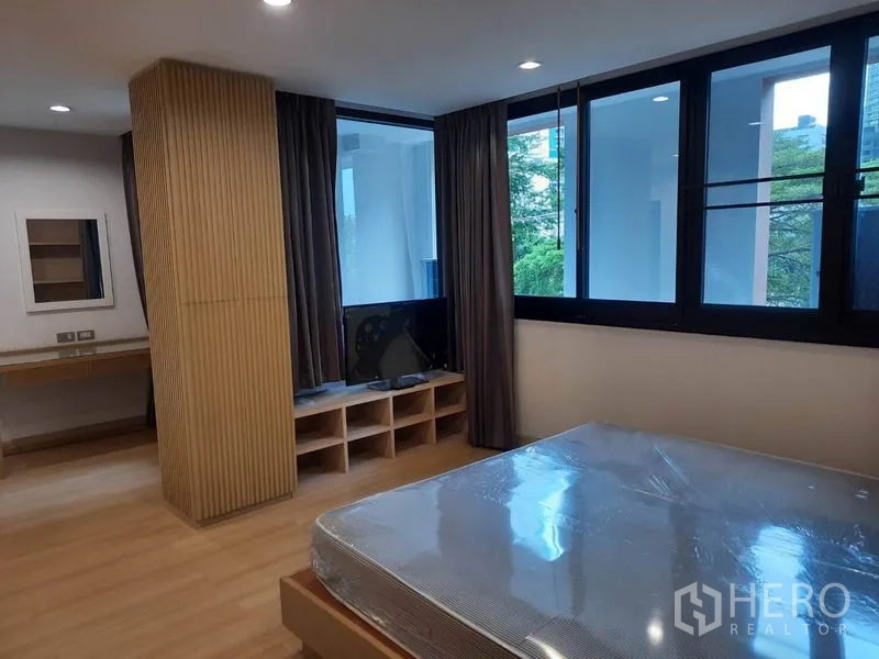 คอนโด ให้เช่าในWatthana, Bangkok - ห้องนอนกว้าง หน้าต่างบานใหญ่ ม่าน ชั้นวางทีวีบิลท์อิน และเตียงบนพื้นไม้