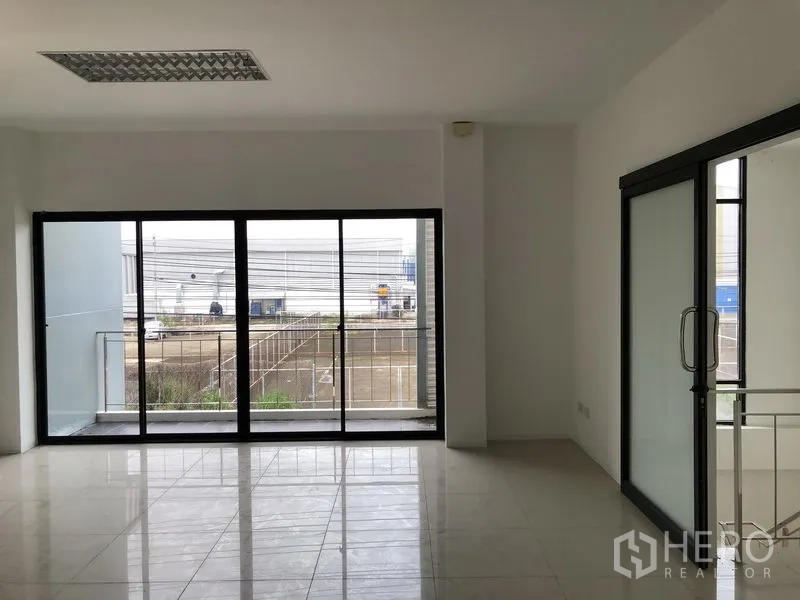 工厂 出租或出售在Bang Phli, Samut Prakan - 办公室大面积落地推拉门，连接阳台并可见园区道路景观。