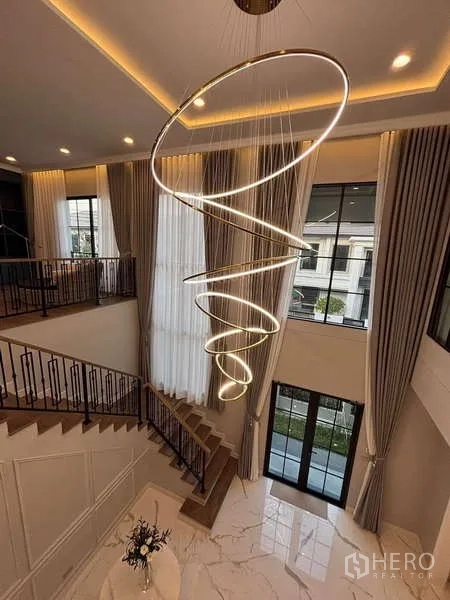 Detached House for rent in Bang Phli, Samut Prakan - Double-volume foyer with dramatic spiral chandelier, tall curtains and stairway.