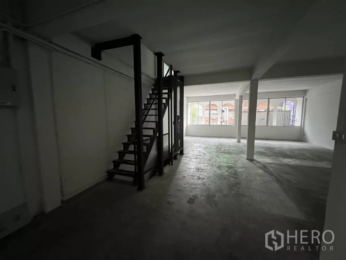 店屋 出租在Watthana, Bangkok - 开阔楼层，面向拱形街景窗，旁边为室内楼梯。