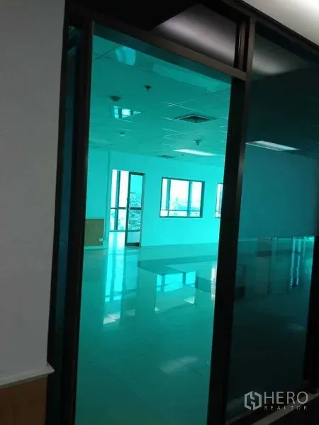 办公空间 出租在Huai Khwang, Bangkok - 玻璃隔断入口通向开放式办公区，瓷砖地面与吊顶照明。