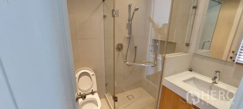 คอนโด ให้เช่าในPathum Wan, Bangkok - ห้องน้ำขนาดกะทัดรัด พร้อมตู้กระจกกั้นอาบน้ำ อ่างล้างหน้าและกระจก ผนังโทนสว่าง