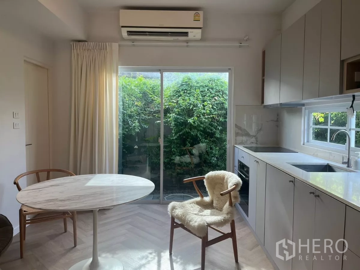 Townhouse for rent in Bang Phli, Samut Prakan - Kitchen-dining area with marble round table, AC and window above the sink.