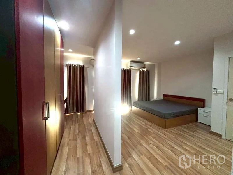 ทาวน์เฮาส์ for rent in Suan Luang, Bangkok - ห้องนอนขนาดใหญ่พื้นไม้ พร้อมผ้าม่านและเตียง